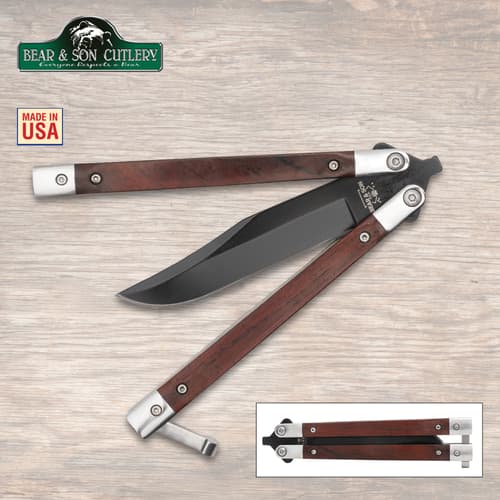 Butterfly knife with wooden handles and black blade on wood background