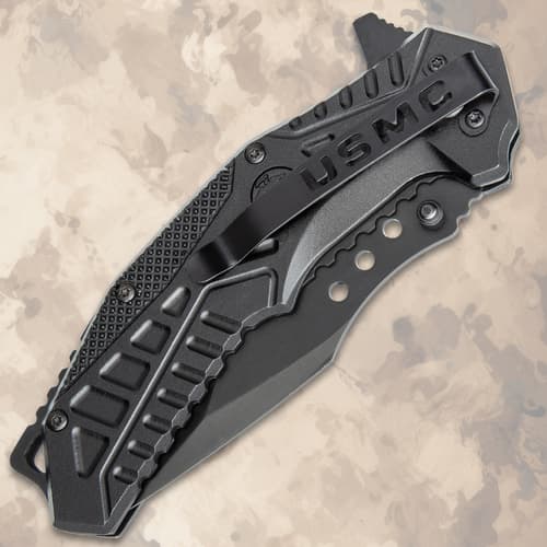 Closed black tactical knife with USMC branding