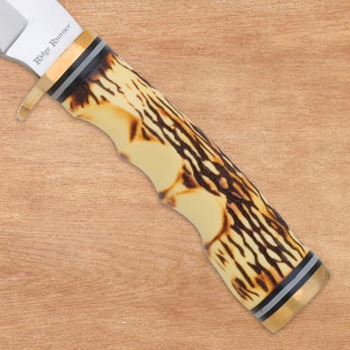 Close-up of burnt jigged bone handle on wood