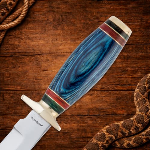 Close-up of knife handle on wooden background with snake
