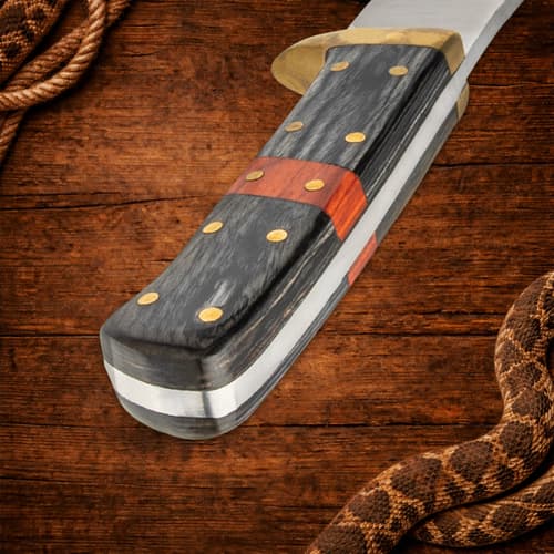 Close-up of knife handle with black, orange, and brass details