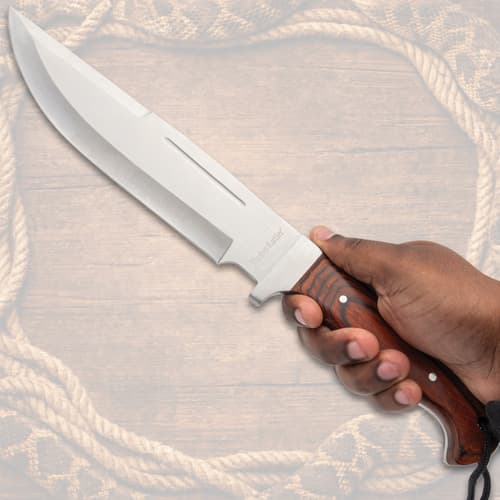 Hand holding large knife with wooden handle
