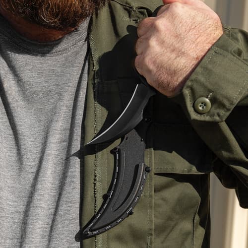 Person holding black knife in sheath on jacket