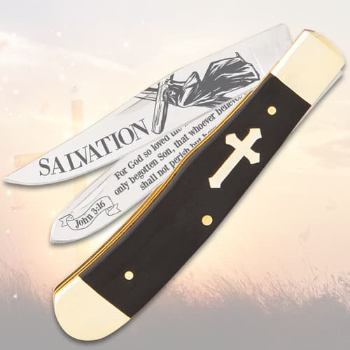 Partially open knife with cross handle and religious text on blades