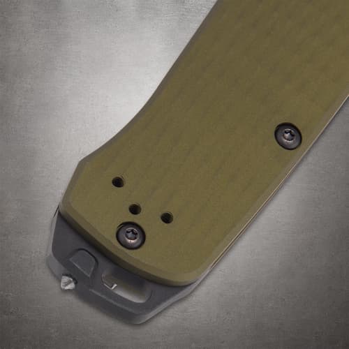 Close-up of green knife handle with metal clip and screws