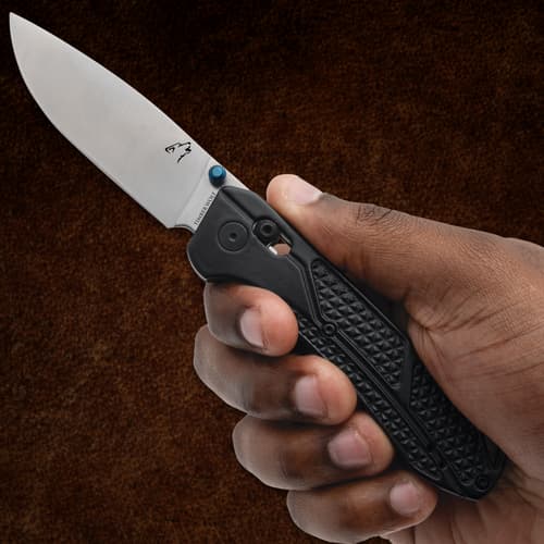 Hand holding a black-handled folding knife with a silver blade