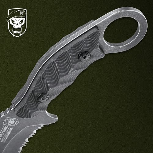 Close-up of knife handle with finger ring on green background