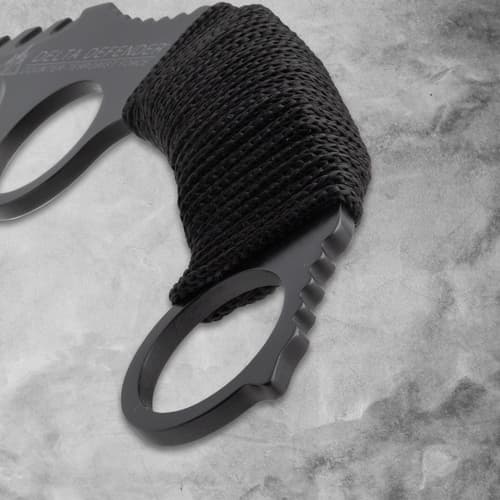 Close-up of the cord-wrapped handle of a black karambit knife