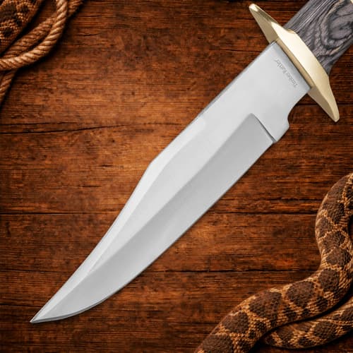 Close-up of knife blade with sharp edge on wooden background