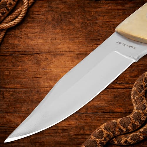Close-up of knife blade on wooden background
