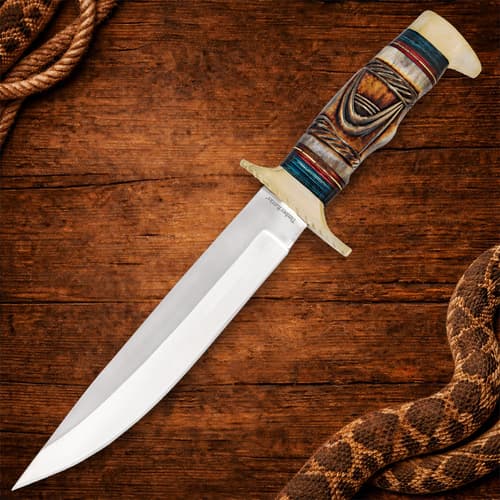 Full view of Bowie knife on wooden surface with snake