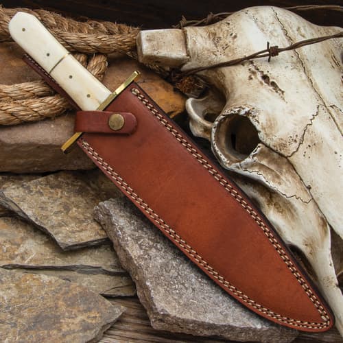 Knife in leather sheath with skull and rope