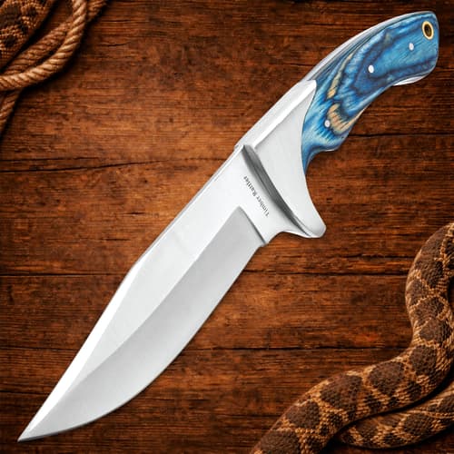 Stainless steel knife with blue handle on wood
