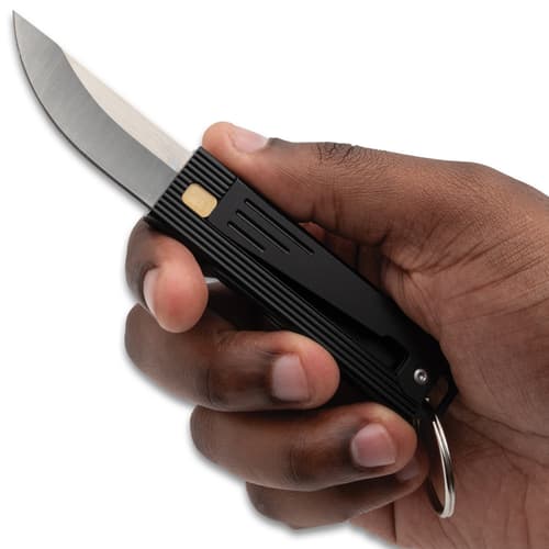 Hand holding a black folding knife with a silver blade
