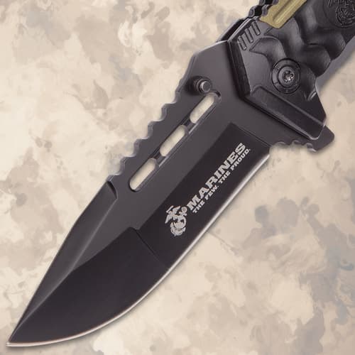 Close-up of black tactical knife blade with USMC logo