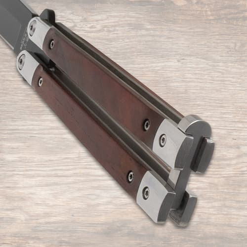 Close-up of butterfly knife's wooden handles and metal details