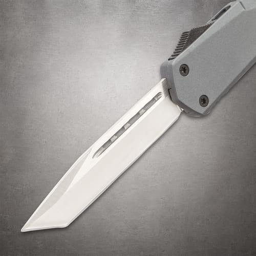 Sharp blade of a tactical knife on a gray background