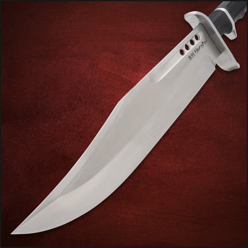 Close-up of knife blade with engraved text on red background