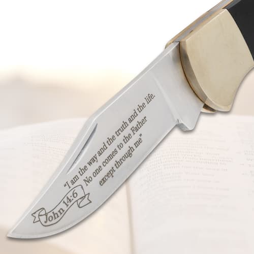 Close-up of engraved knife blade on open book