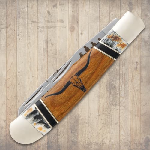 Closed knife with wooden handle and engraved blade