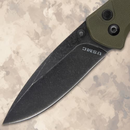 Close-up of the black blade of a USMC folding knife