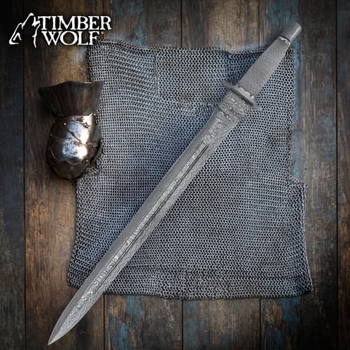 Sword on chainmail with gauntlet on wooden surface