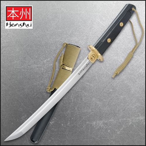 Tactical tanto with black handle and gold accents on a textured background