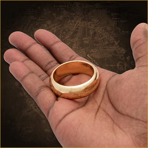 Gold ring with inscription held in a hand