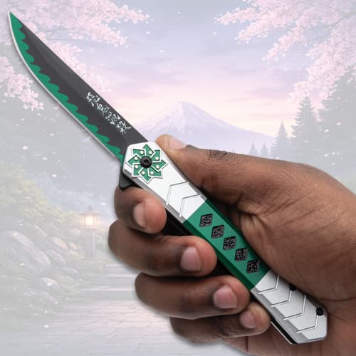 Hand holding a green and silver pocket knife, scenic backdrop
