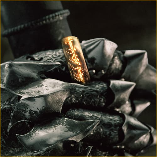 Gold ring with glowing inscription on armored hand