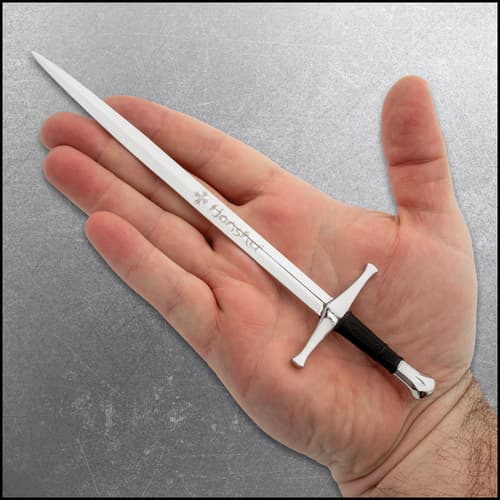 Sword-shaped letter opener resting on a hand