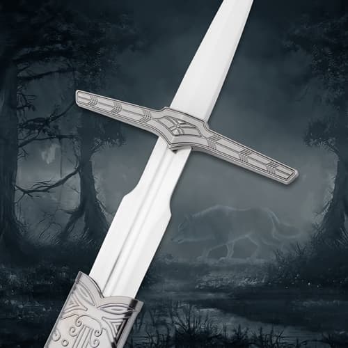 Close-up of sword hilt with engraved design, wolf in misty forest