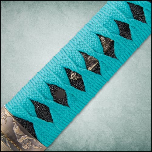 The scabbard has a teal braided nylon hanging cord.