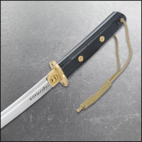 Close-up of tanto handle with gold accents and paracord wrap