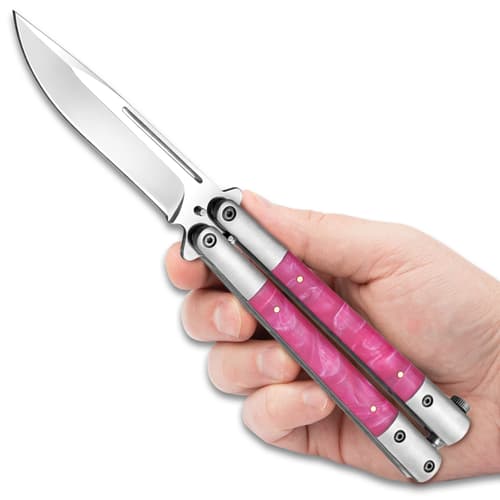 Hand holding a butterfly knife with pink marble handle