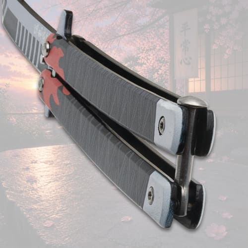 Close-up of butterfly knife handle with flame design