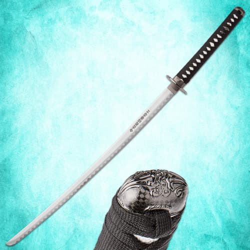 Full view of katana sword with detailed pommel on turquoise background