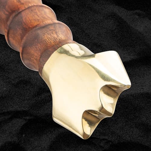 Close-up of sword's brass pommel and wooden handle