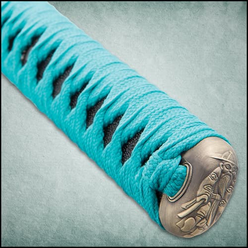 Zoomed view of the cast metal tsuba and teal cord wrapping the handle.