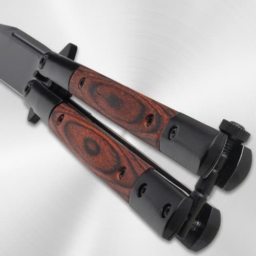Close-up of butterfly knife's wood handle and latch