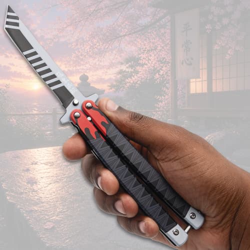 Hand holding a butterfly knife with flame design