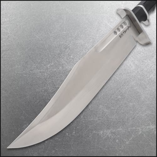 Close-up of knife blade showing sharp edge and engraved text