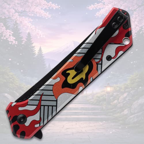 Folded knife with flame design and pocket clip, scenic backdrop