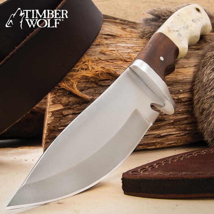 Timber Wolf Adrian Trail Knife has a full-tang 4 1/2” stainless steel blade with gut hook and natural bone and walnut wood handle scales.