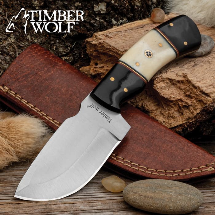 The Timber Wolf River Run Skinner Knife has black and natural bone handle scales accented with a rosette and fileworked spacers