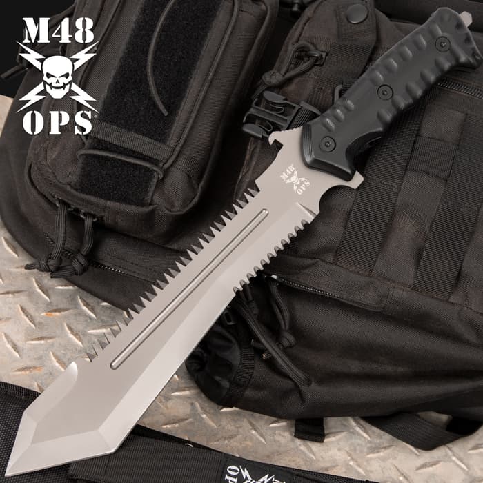 M48 OPS Combat Bowie has a titanium electroplated stainless steel blade and reinforced impact-resistant handle on a tactical background.