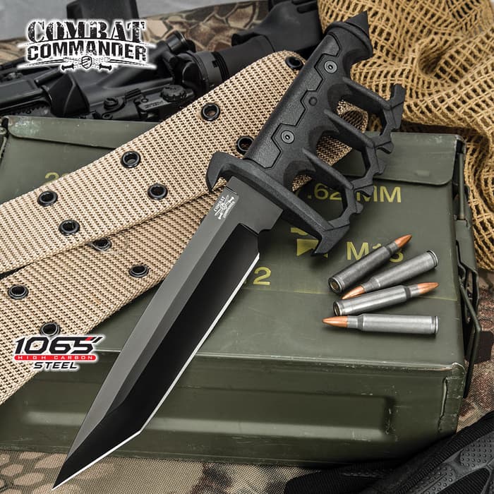 Combat Commander Trench Knife has a 1065 carbon steel blade and cast metal handle with rubberized grip inserts, shown on ammunition background.