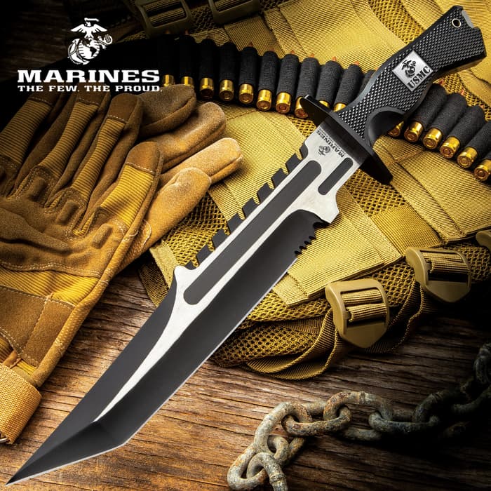 Large knife with silver and black accents of both the blade and the handle with an overall tactical styling on a background of military gear. 
