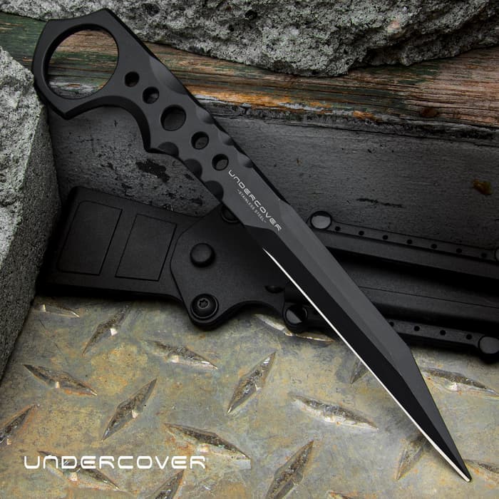 Slim black 7 1/4" stinger knife with an open ring pommel and the text "UNDERCOVER" displayed in the center of the knife and in the bottom left corner. 
