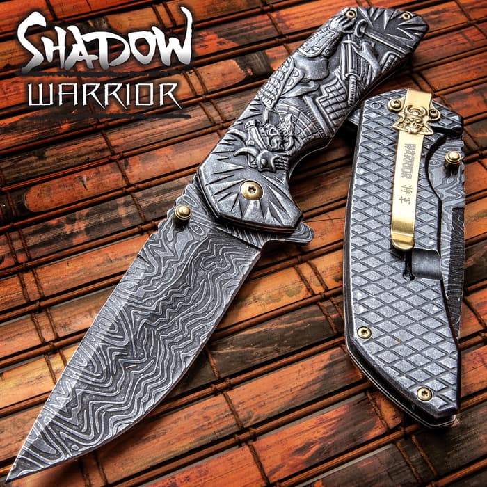 The Shadow Warrior Assisted Opening Knife has an ornate handle and 3 1/2” DamascTec steel blade.